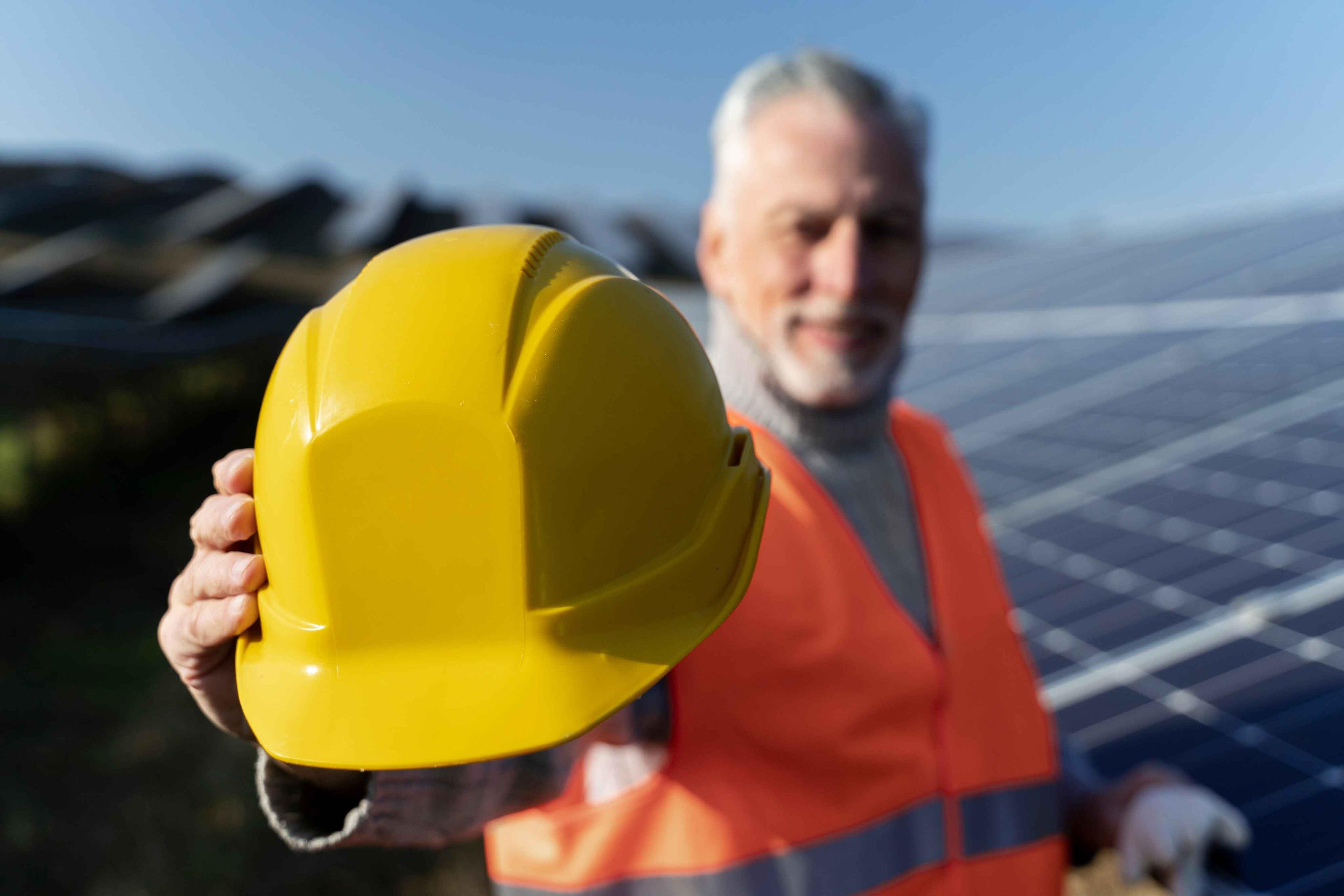 experienced technician standing beside solar panels