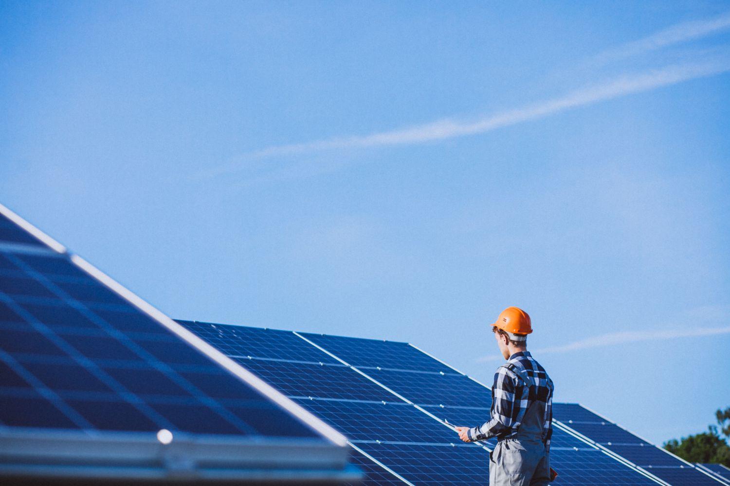 technician standing infront of solar panels